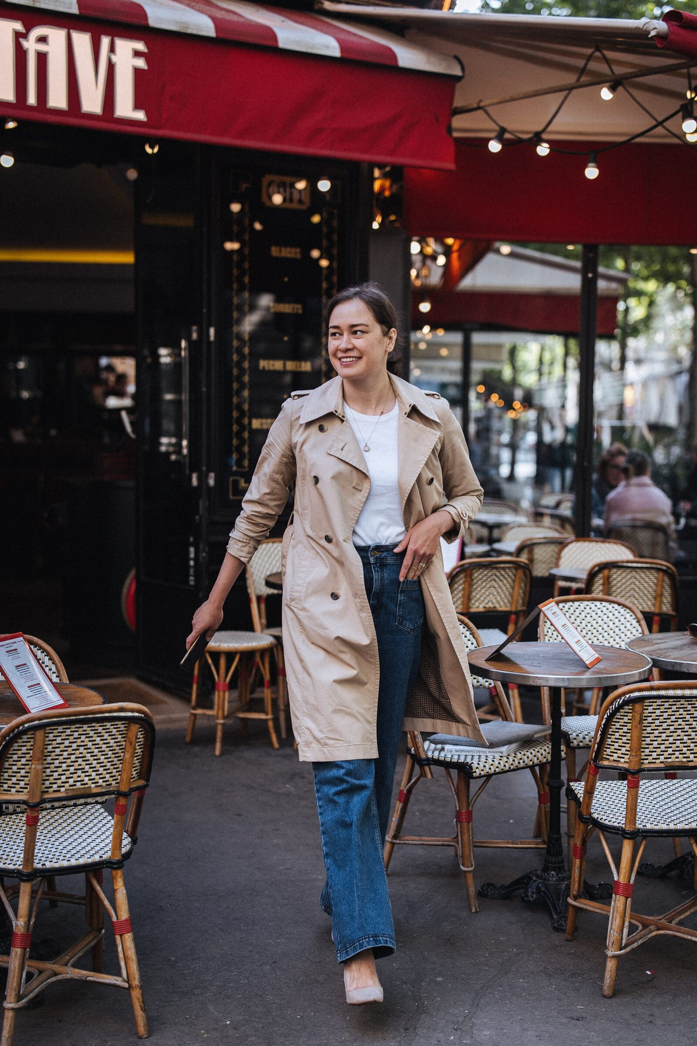 Aliya walking past a Paris café